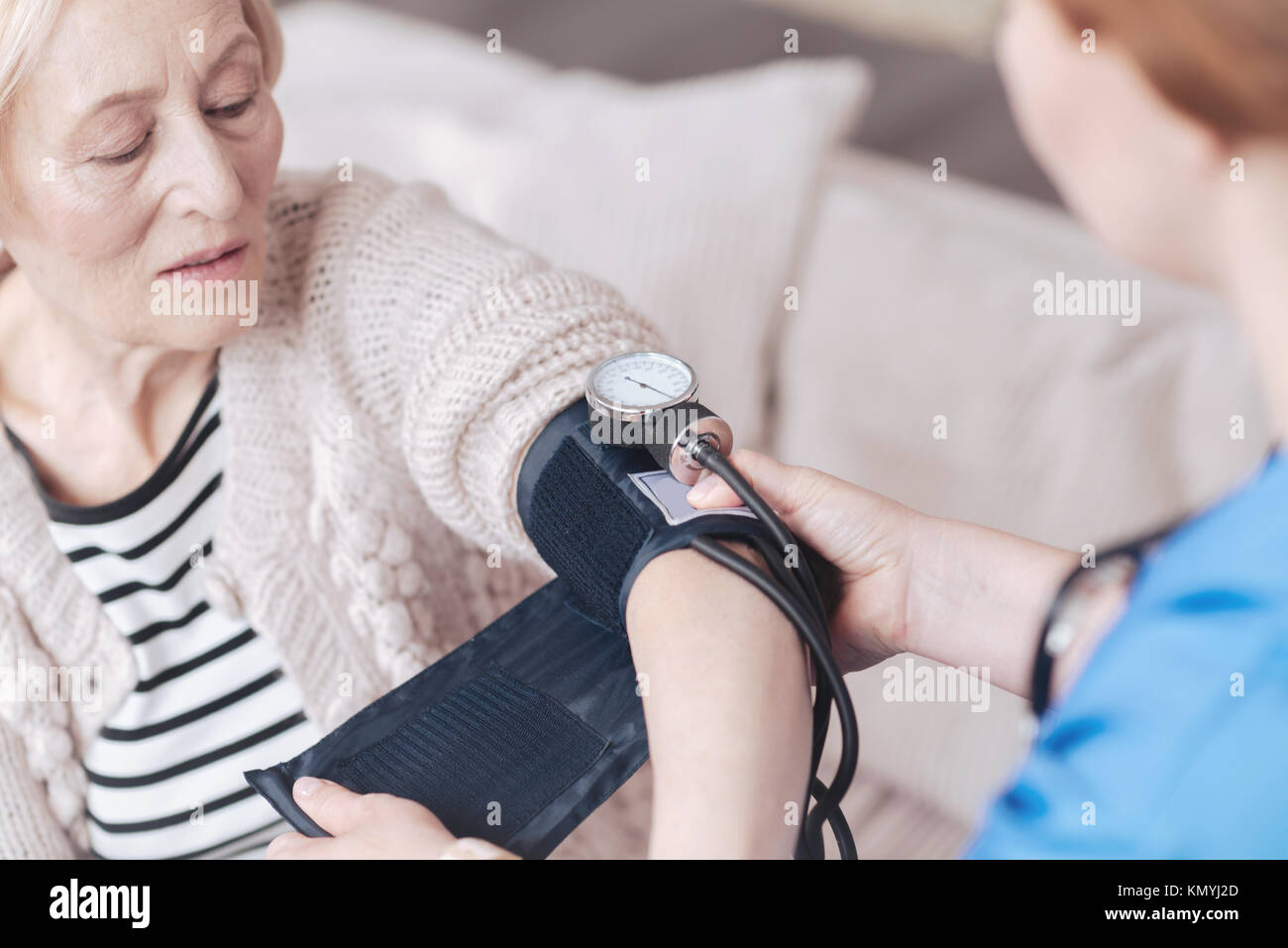 Scalata vista sull'infermiera misurazione della pressione della donna senior Foto Stock