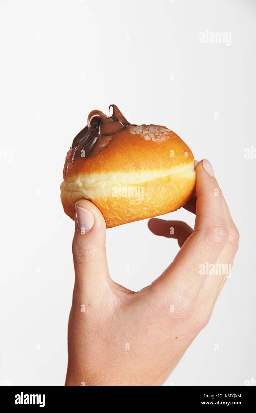 Azienda ciambella dolce ( Sufganiyah) una tradizionale ciambella ebraica mangiato durante Hanukkah, con un sacco di piacere e calorie Foto Stock