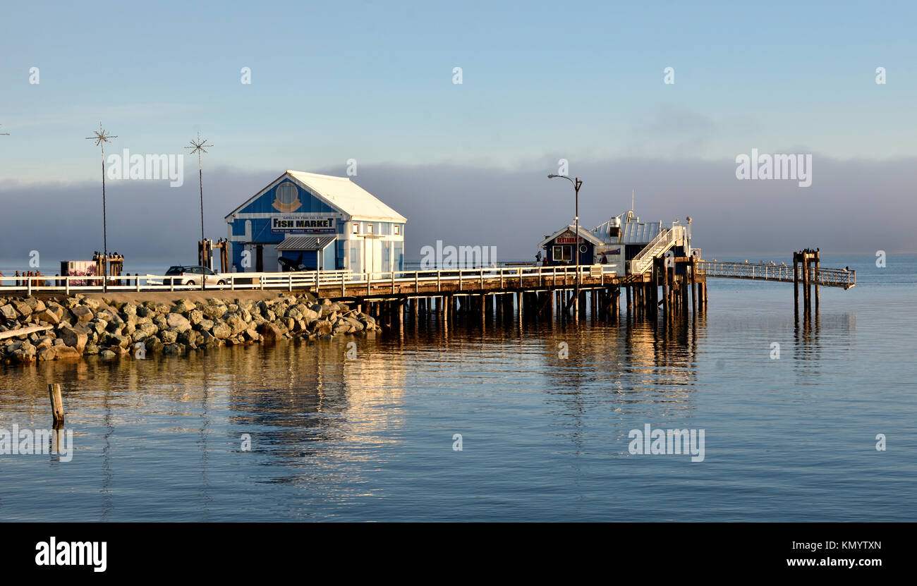 Mercato sul molo con un banco di nebbia in background di Sidney, BC Foto Stock