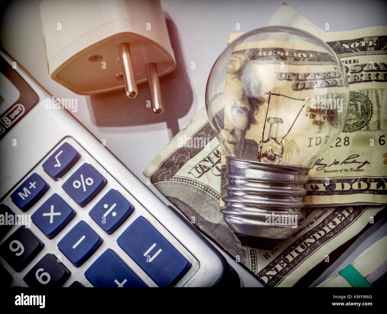 Calcolatrice e denaro accanto a una lampadina, il concetto di risparmio energetico Foto Stock