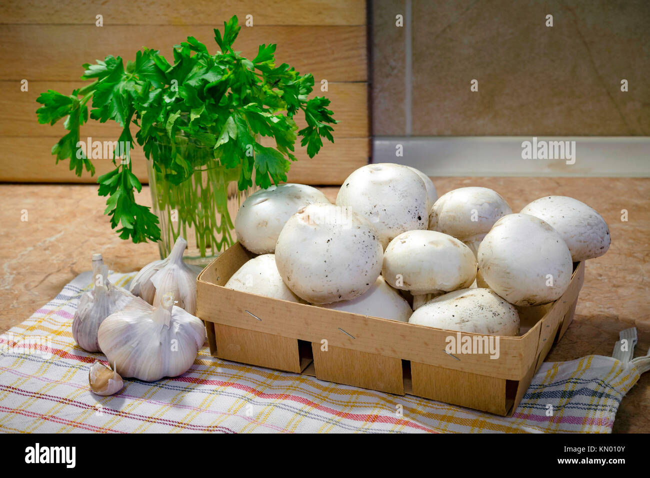 Preparazione di 'funghi trifolati' (a fette sottili gli champignon cotti con olio, aglio e prezzemolo) Foto Stock