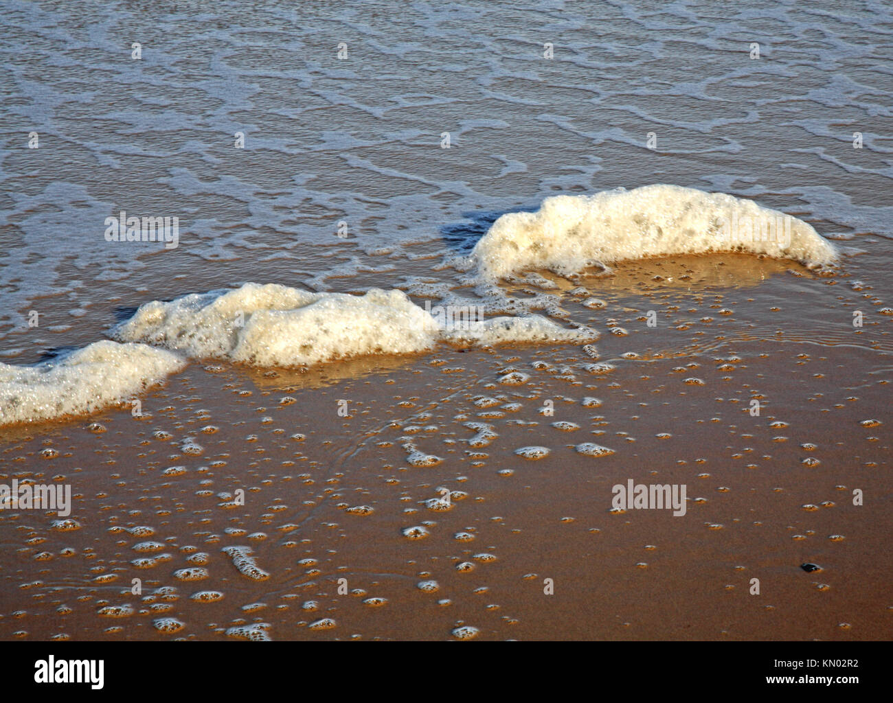 Una vista della schiuma del mare del Nord Norfolk beach a East Runton, Norfolk, Inghilterra, Regno Unito. Foto Stock