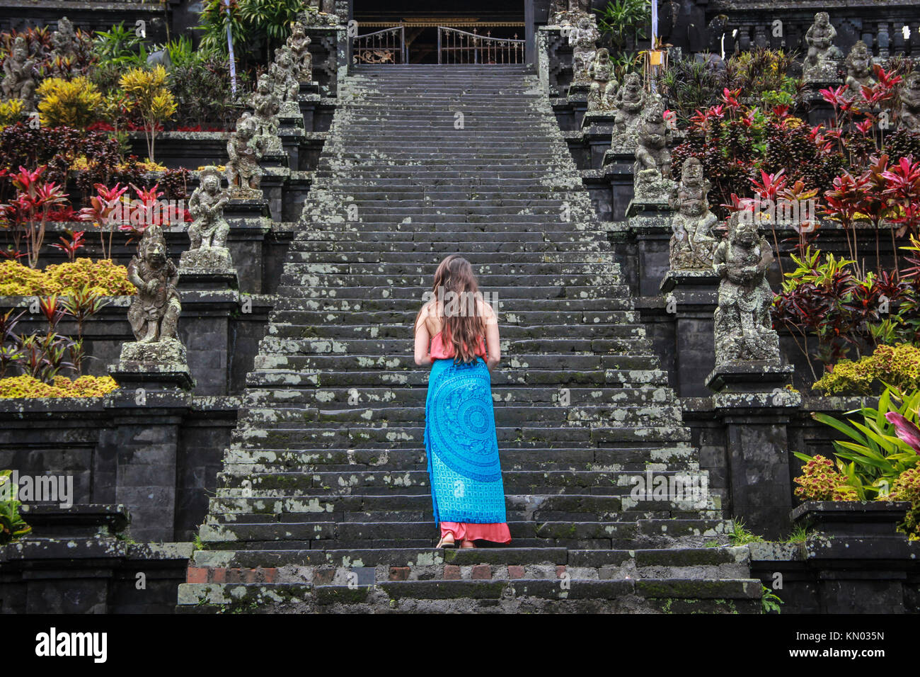 Europea femminile pone turistica indietro nella parte anteriore del tempio Besakih Bali - Indonesia Foto Stock