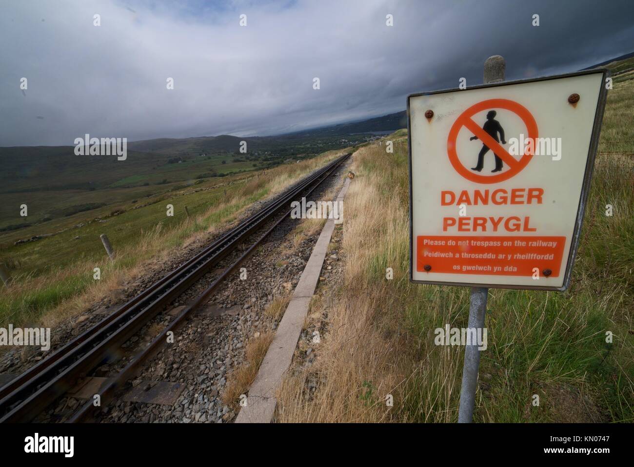 Binario ferroviario lungo Snowdon Mountain nel Parco Nazionale di Snowdonia, Galles. Segnaletica di pericolo lungo la ferrovia. via. Pericolo peryol. Foto Stock