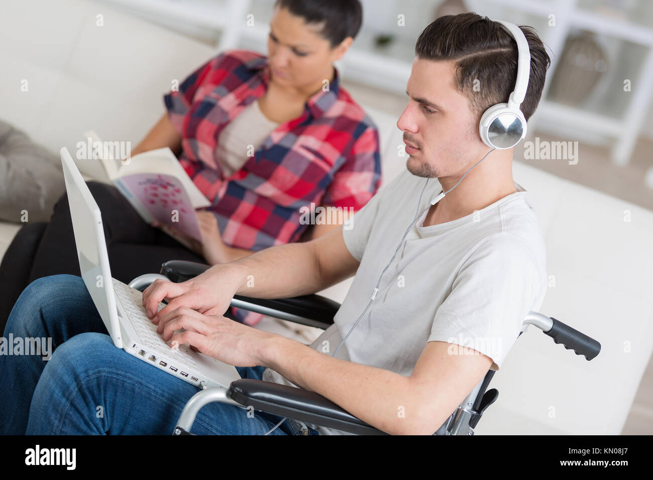 Disabilitato l'uomo utilizzando laptop seduto accanto alla sua ragazza Foto Stock