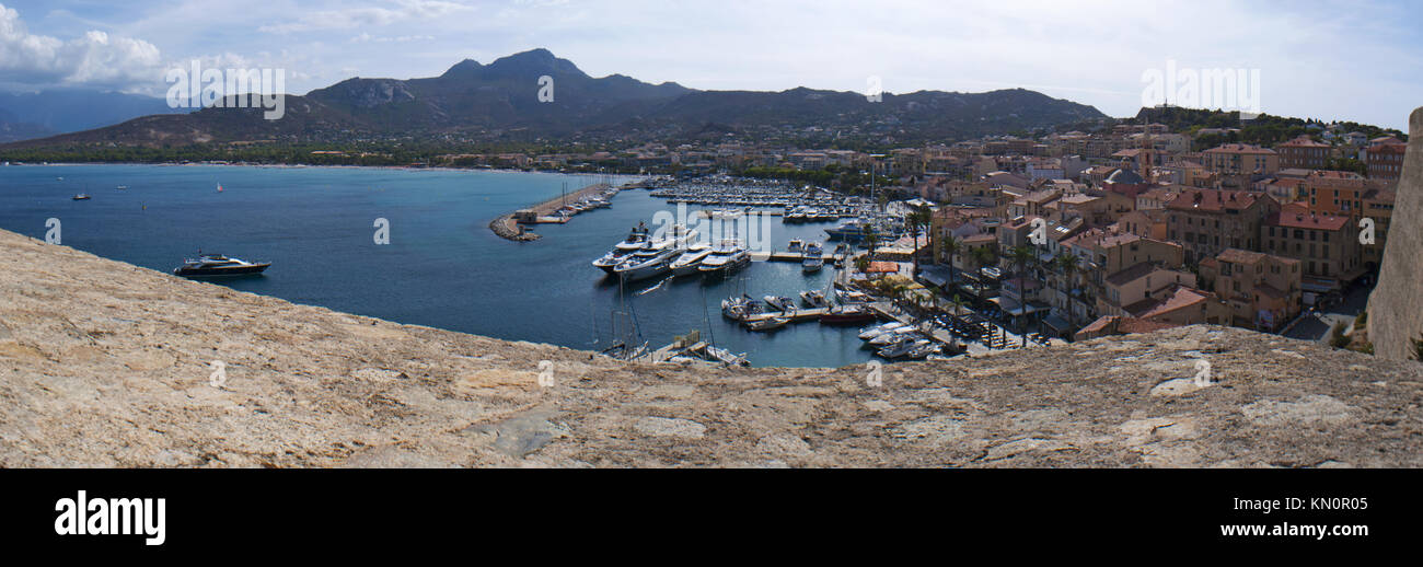 Corsica: Mare Mediterraneo con le barche in marina e dello skyline di Calvi si vede dalle antiche mura di Cittadella Foto Stock