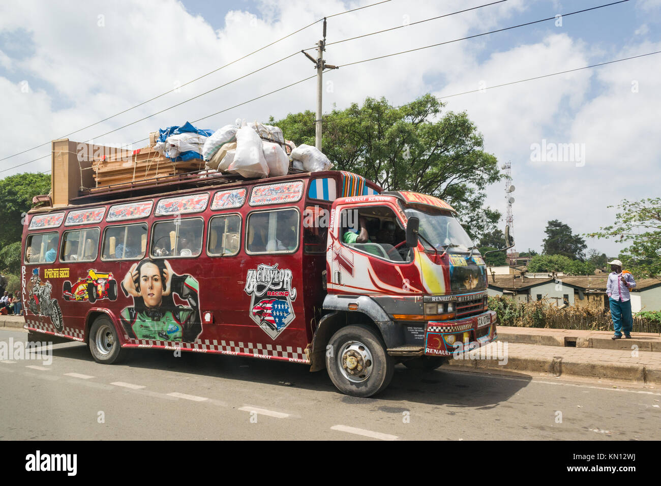 Un autobus decorato con arte arrestata dal lato della strada, molto carico con merci sul tetto, Nairobi, Kenya, Africa orientale Foto Stock