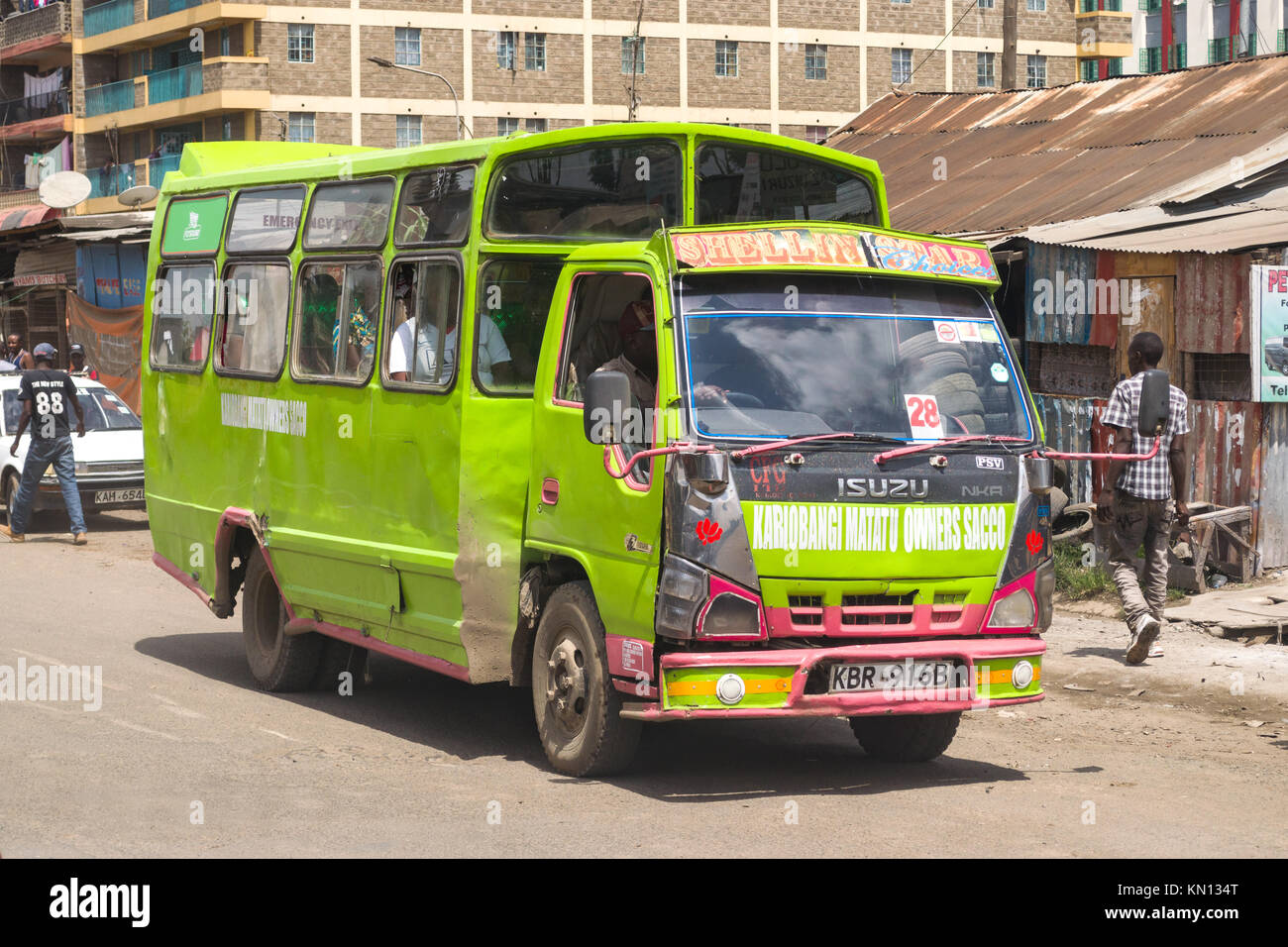 Un vivacemente colorato autobus verde di guidare su strada, Nairobi, Kenya, Africa orientale Foto Stock