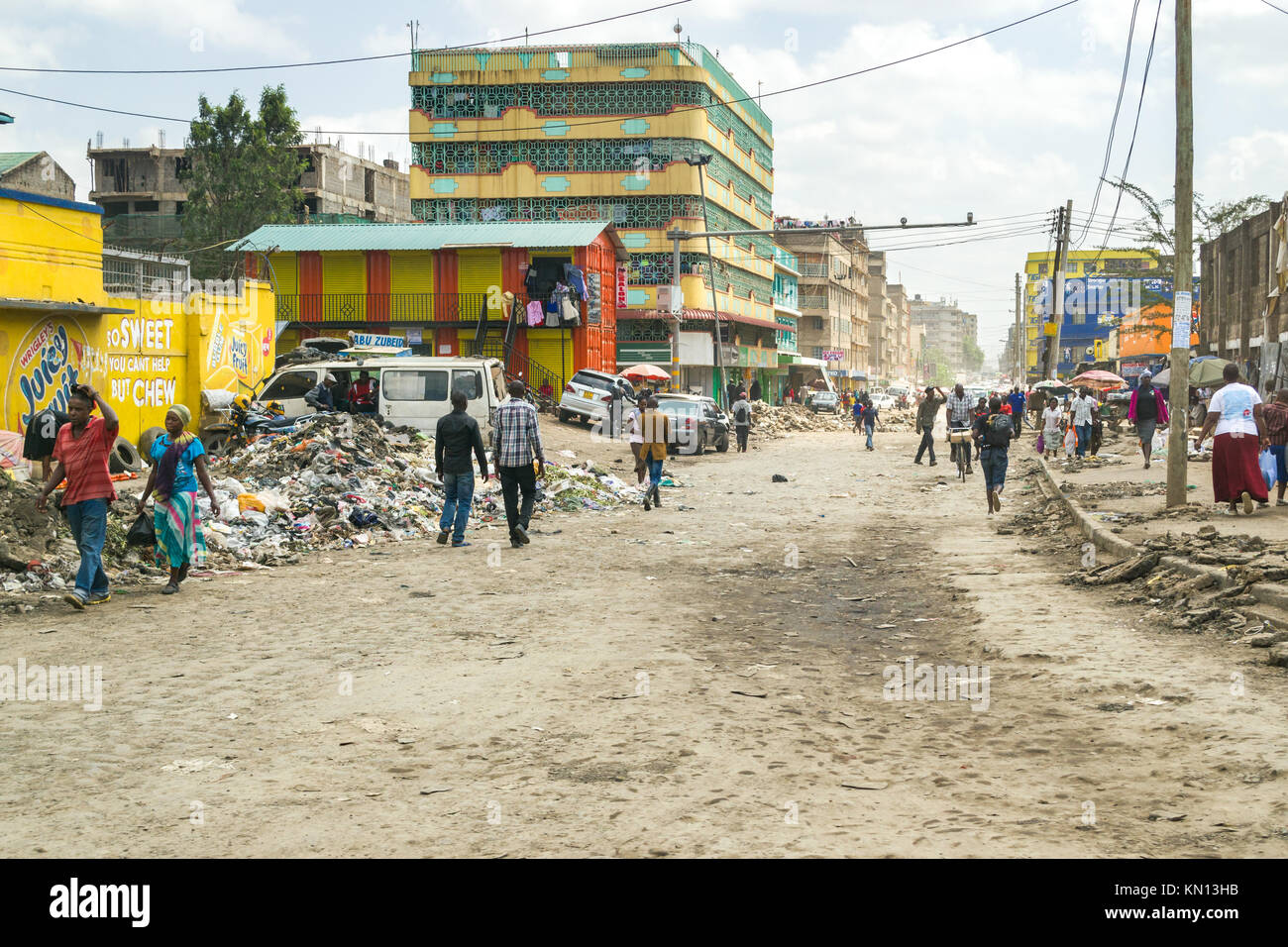 Una vista giù per una strada in Eastleigh area con le persone camminare davanti a un gran mucchio di rifiuti generici spazzatura, Nairobi, Kenya, Africa orientale Foto Stock