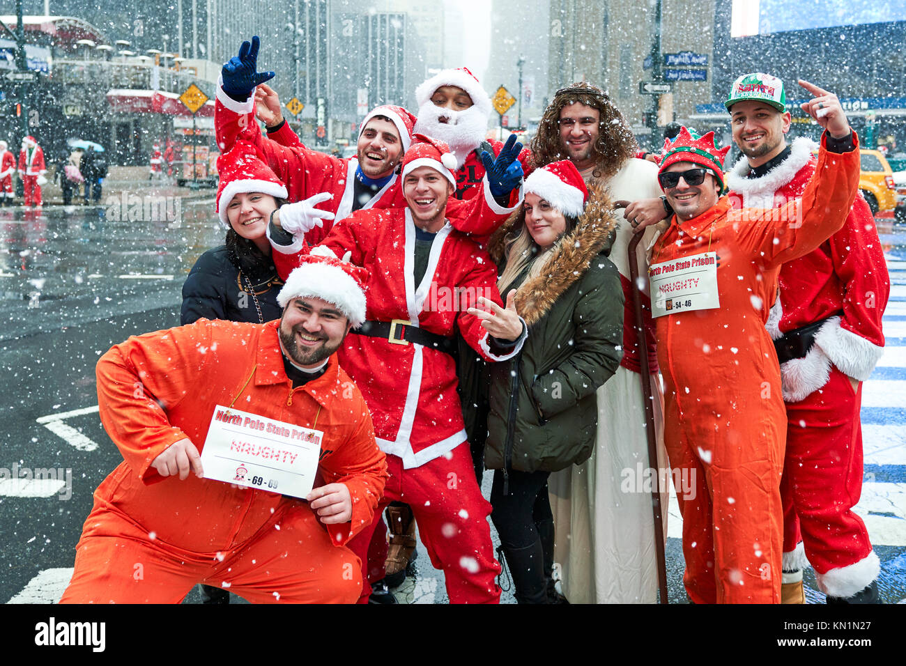 New York, Stati Uniti d'America, 9 Dic 2017. Persone che indossano il Natale-costumi correlati pongono sotto una tempesta di neve in una festosa 'Santacon' folla raccolta. Foto di Enrique Shore/Alamy Live News Foto Stock