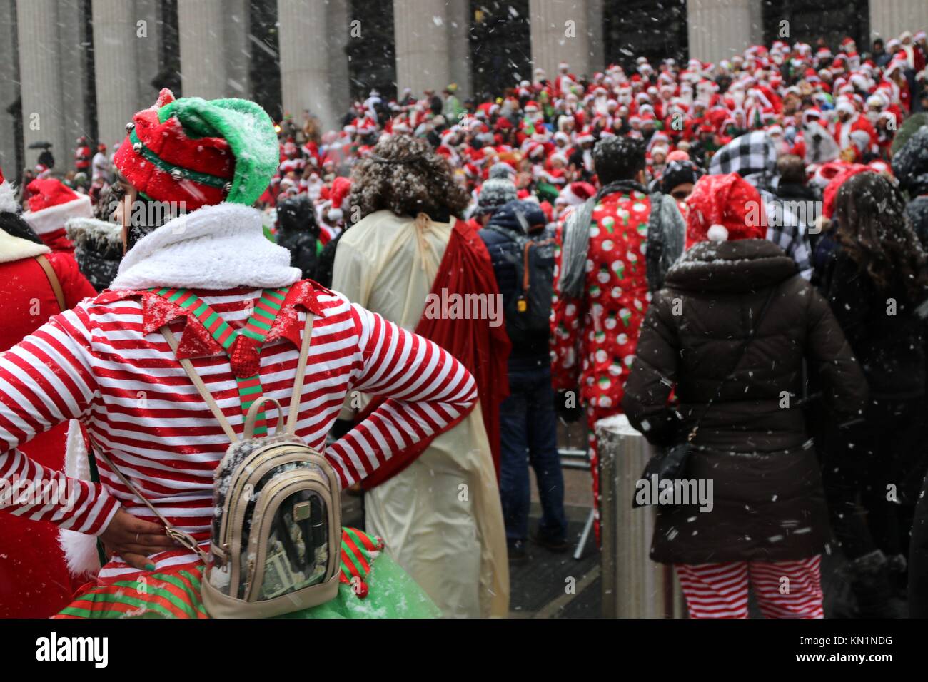 New York, NY, USA. 9th. Dic, 2017. Inizio a Copenaghen nel 1974, il pub crawl che ogni anno attirano migliaia di Santa-placcati revealers, arrivati negli Stati Uniti in 1994 ed è diventato il più grande pub crawl in tutto il mondo dal 1998 con la sua New York arrivo. Migliaia, sotto la prima neve giorno del 2017 stagione invernale si sono riuniti presso il punto di adunata in New York City, prima dell invasione di Babbo Natale ha iniziato la città-ampia ricerca per indicizzazione. © 2017 G. Ronald Lopez/DigiPixsAgain.us/Alamy Live News Foto Stock