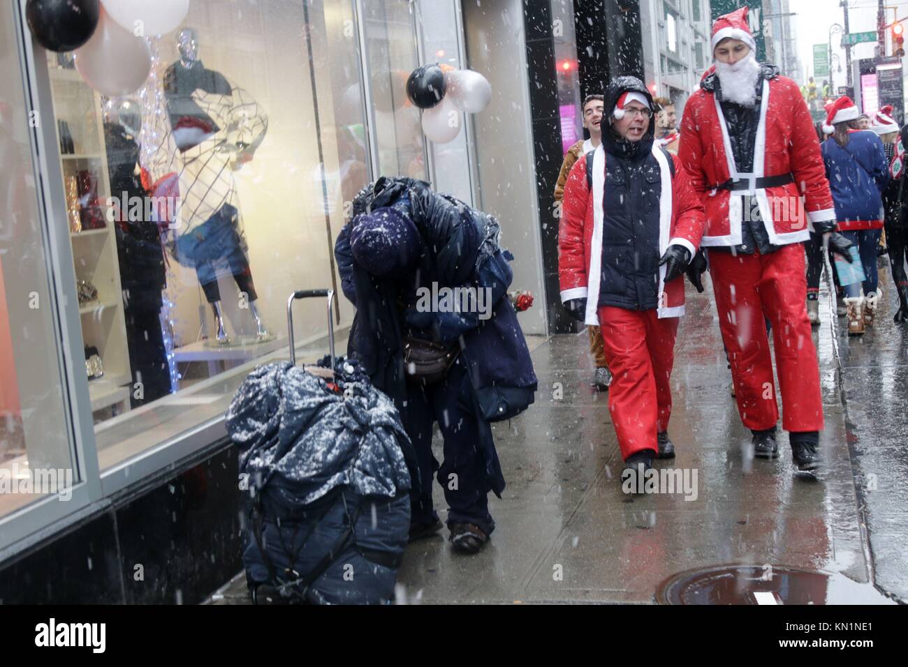 New York, NY, USA. 9th. Dic, 2017. Inizio a Copenaghen nel 1974, il pub crawl che ogni anno attirano migliaia di Santa-placcati revealers, arrivati negli Stati Uniti in 1994 ed è diventato il più grande pub crawl in tutto il mondo dal 1998 con la sua New York arrivo. Migliaia, sotto la prima neve giorno del 2017 stagione invernale si sono riuniti presso il punto di adunata in New York City, prima dell invasione di Babbo Natale ha iniziato la città-ampia ricerca per indicizzazione. © 2017 G. Ronald Lopez/DigiPixsAgain.us/Alamy Live News Foto Stock