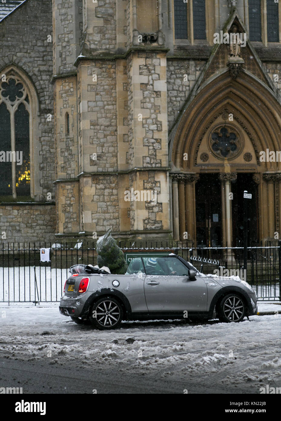 Stoke Newington, Hackney, Londra, Regno Unito. 10 dicembre, 2017. La neve cade a Stoke Newington, Londra. Uomo in Mini con softop verso il basso e verso l'albero di Natale in auto su Stoke Newington Church Street. Credito: Carol moiré/Alamy Live News. Credito: Carol moiré/Alamy Live News. Foto Stock