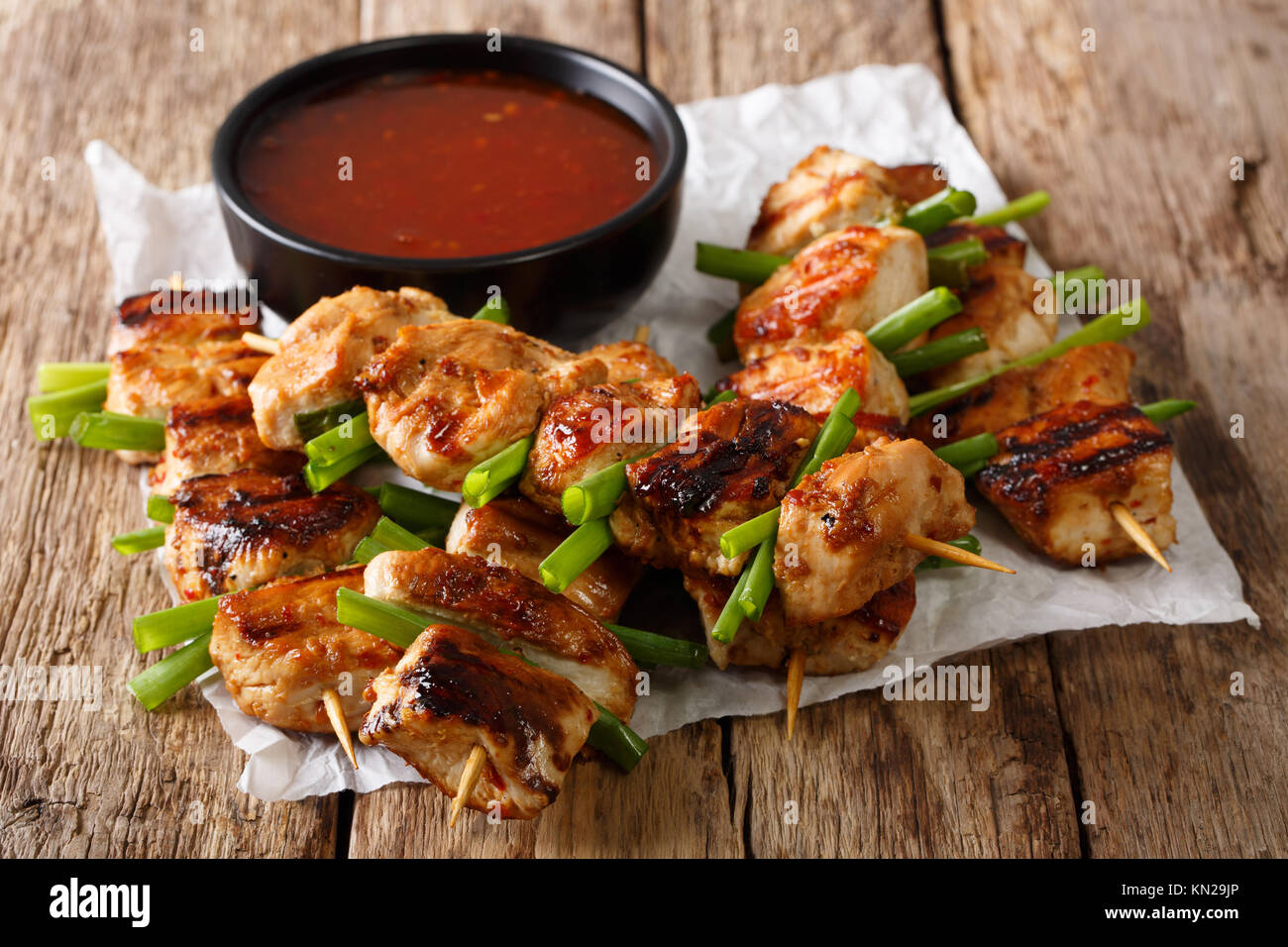 Asian piccante spiedini di pollo con cipolla verde e salsa di peperoncino close-up su una tavola orizzontale. Foto Stock