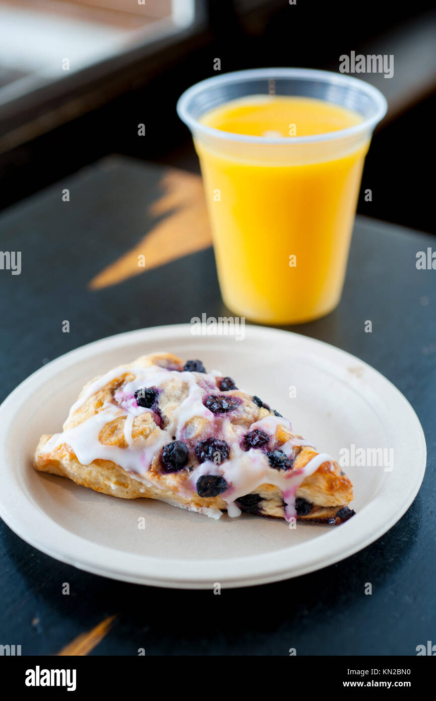 Piatti per la colazione USA mirtillo scone e succo di arancia su una tavola di ristorante Foto Stock