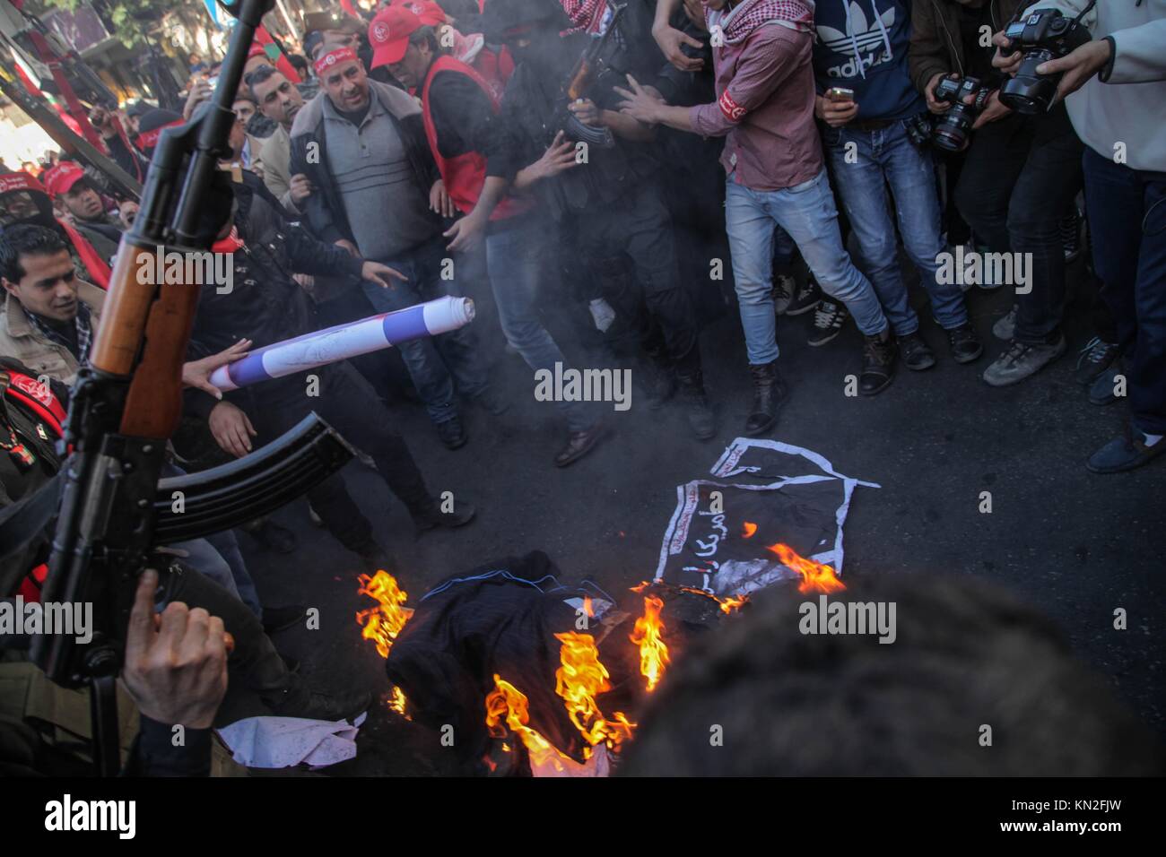 La striscia di Gaza, la Palestina. 09Dec, 2017. Sostenitori palestinesi del Fronte Popolare per la liberazione della Palestina (PFLP) prendere parte a una manifestazione di protesta contro il presidente statunitense Trump per la decisione di riconoscere Gerusalemme come capitale di Israele e palestinesi banditi mascherati del Fronte Popolare per la liberazione della Palestina punto le loro pistole a un'effigie del Presidente americano Donald Trump, nella città di Gaza, Sabato, Dicembre 9, 2017. Credito: Ramez Habboub/Pacific Press/Alamy Live News Foto Stock