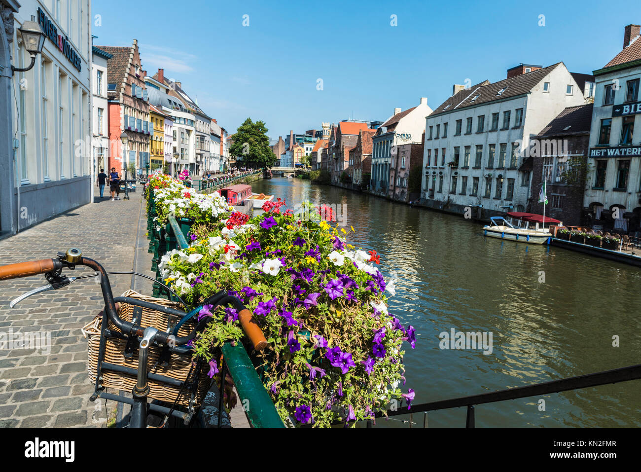 Ghent, Belgio - 29 agosto 2017: Biciclette parcheggiate e vaso di fiori lungo il fiume Leie nella città medievale di Gent, Belgio Foto Stock