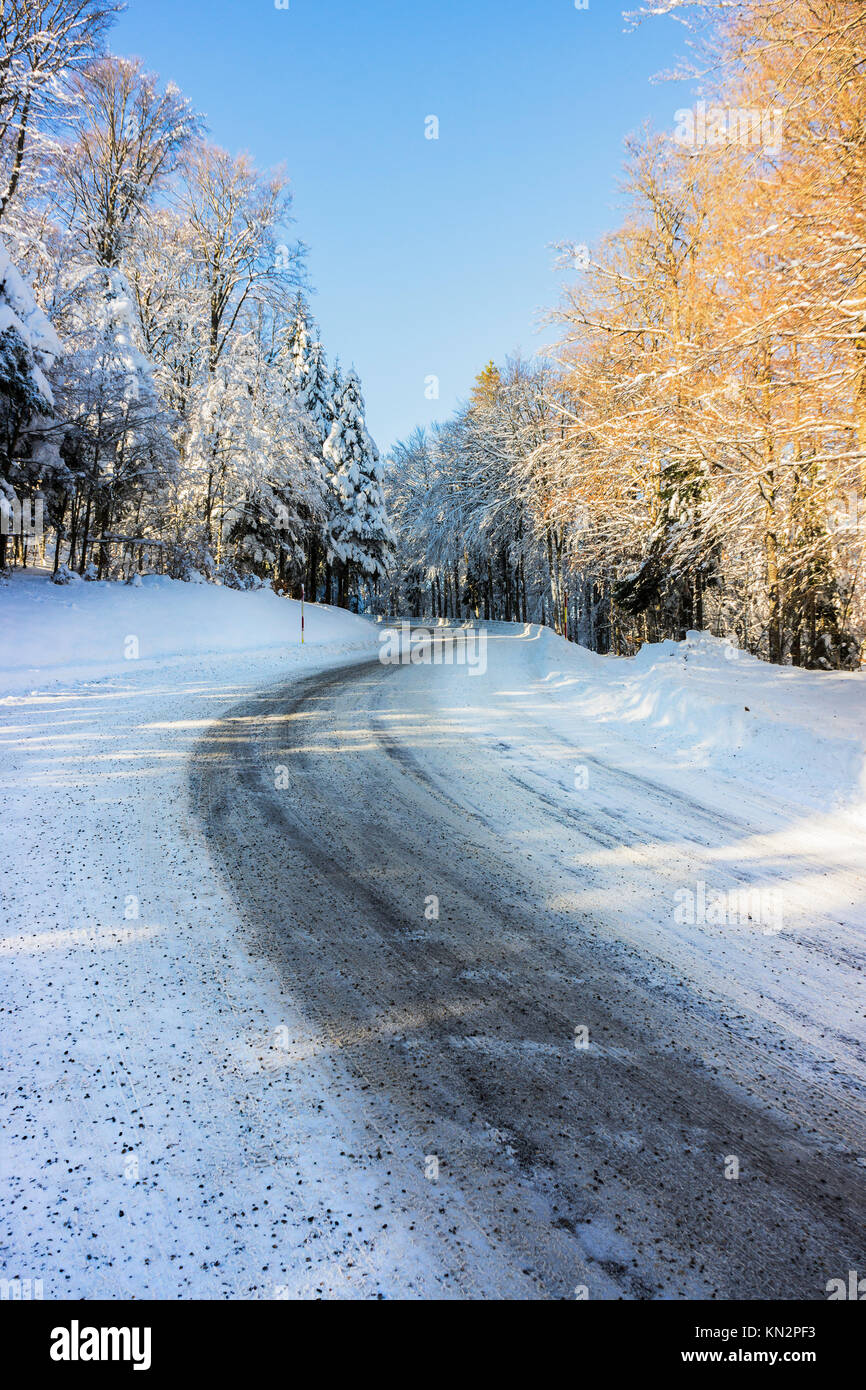 Una presenza di neve e ghiaccio curva su strada nelle montagne Vosges (Francia) in inverno - dicembre 2017 - verticale Foto Stock
