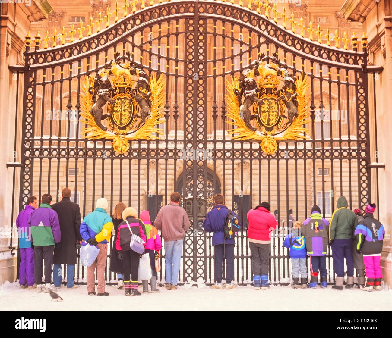 Turisti che si trovano nella neve di fronte a Buckingham Palace Gates, scena invernale di Londra, Inghilterra, Regno Unito Foto Stock