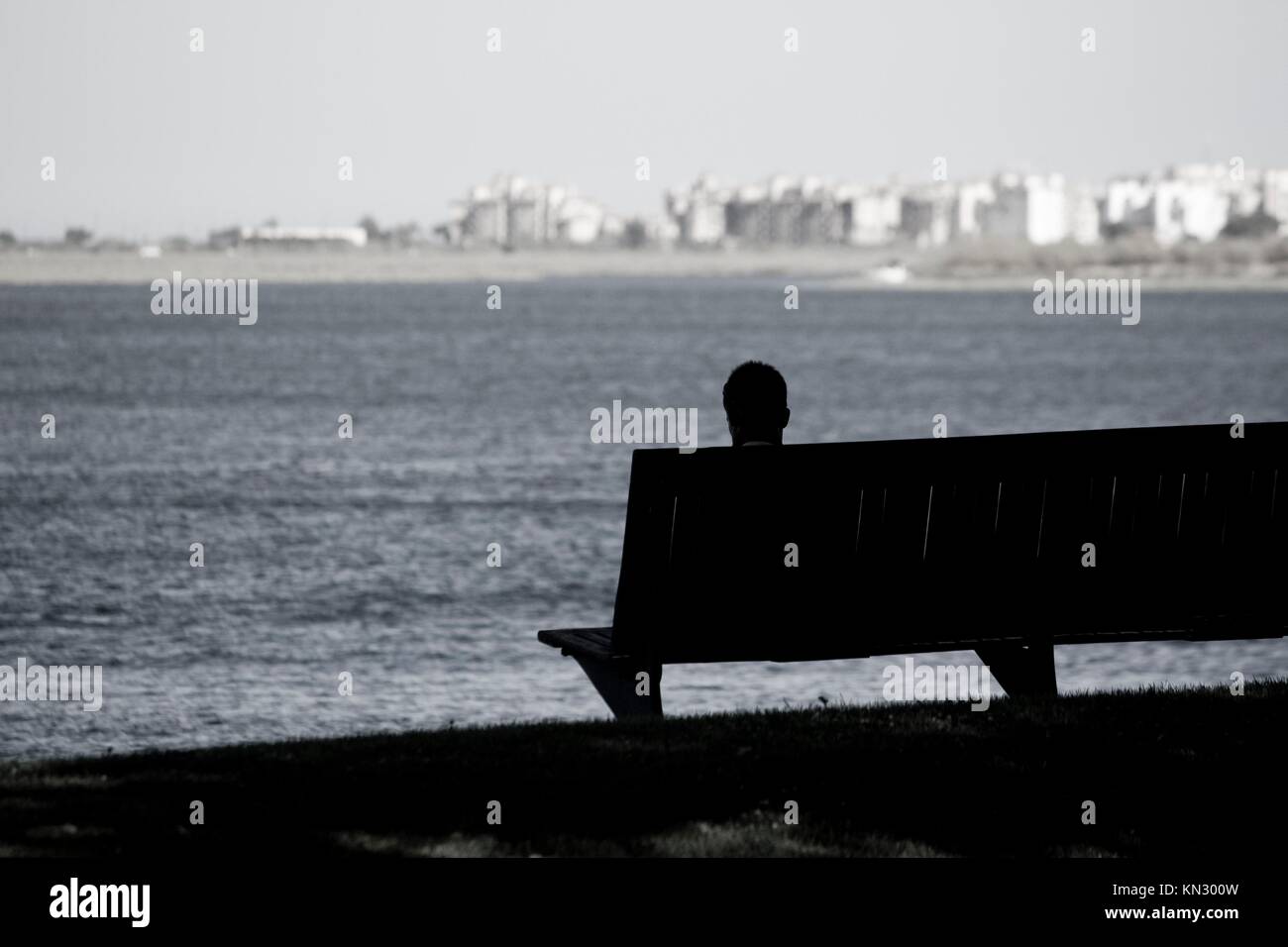 Vista di un banco di lavoro e la testa di un uomo stagliano guardando la città e il mare. Foto Stock