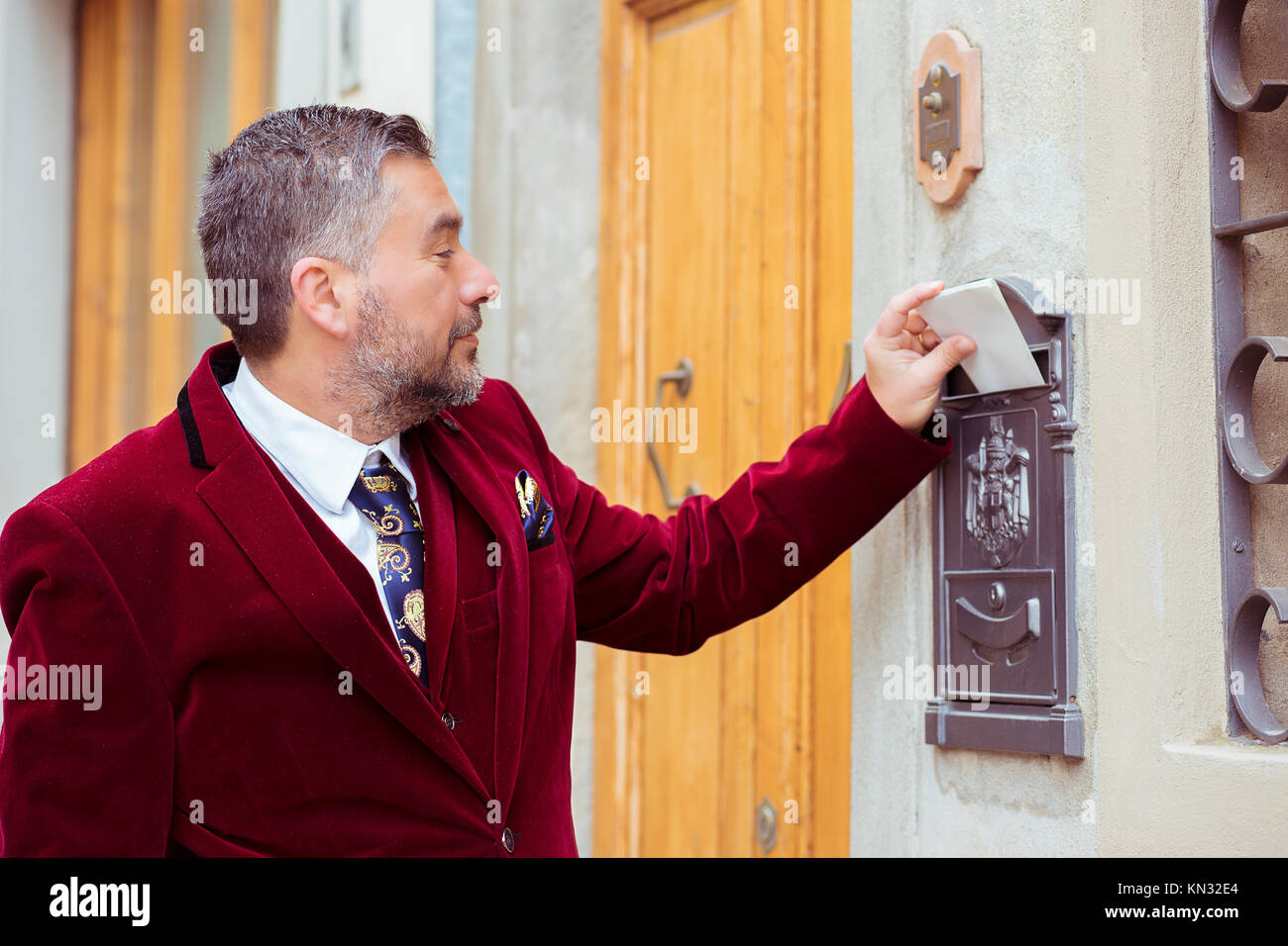 Bello imprenditore inviando una lettera e documenti tramite cassetta postale. Foto Stock