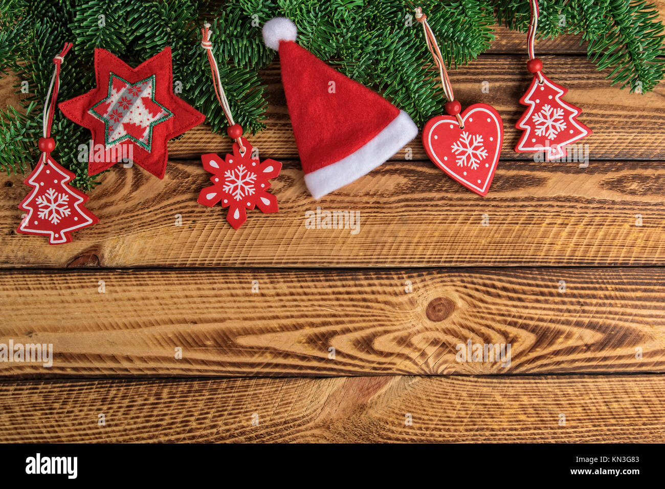 Vacanze di Natale sfondo con Santa hat e decorazioni rosso scuro sul tavolo di legno Foto Stock