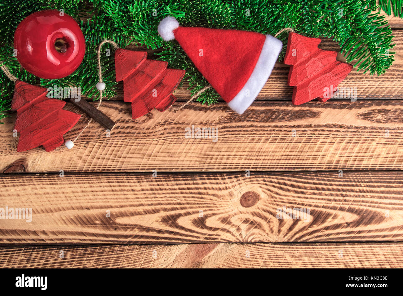 Rosso di natale decorazione vintage con Santa hat su tavole di legno. Natale sfondo vintage con lo spazio di testo Foto Stock