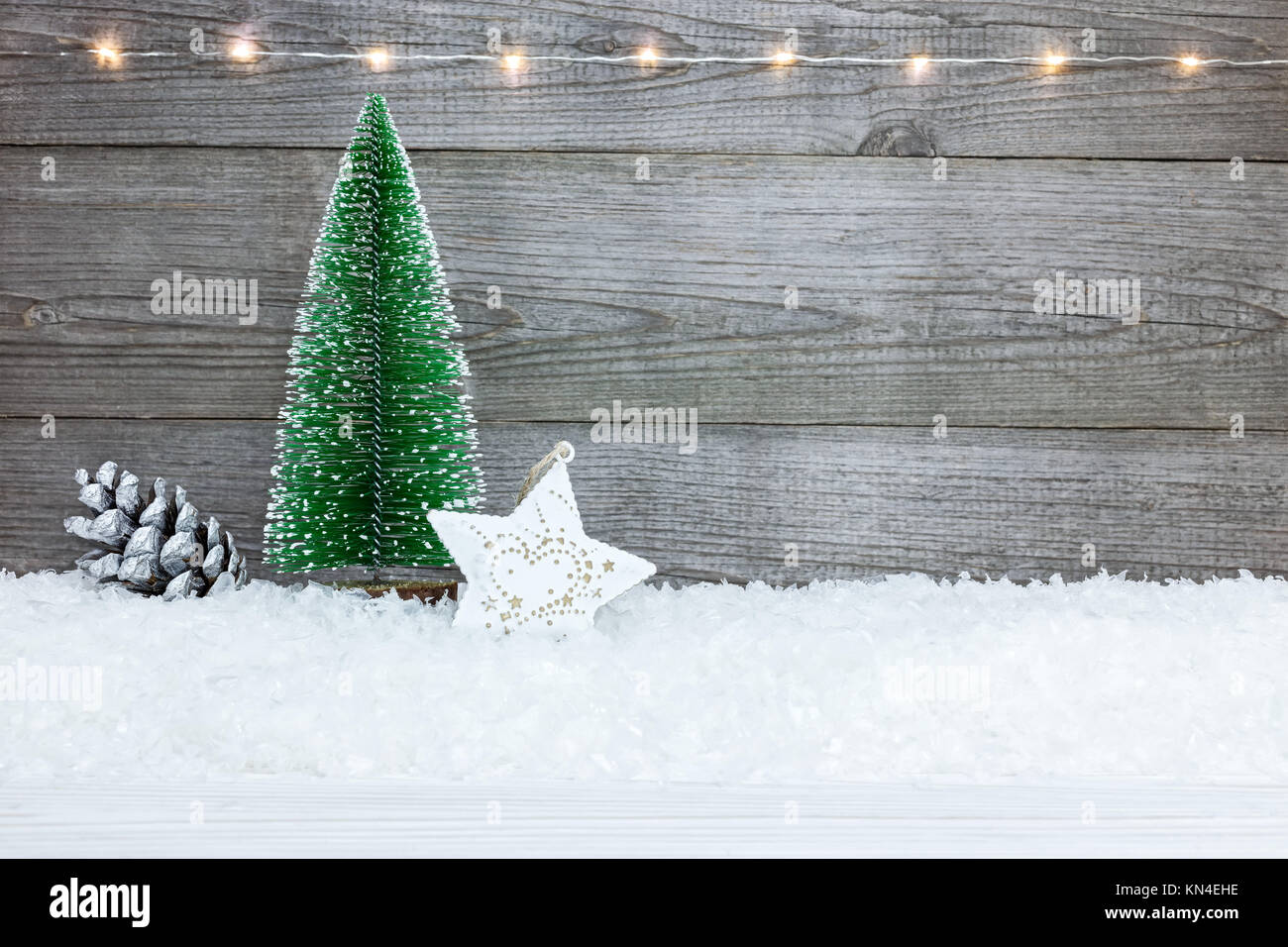 Sfondo di natale con abete, stella, cono di pino e neve su rustiche tavole di legno Foto Stock