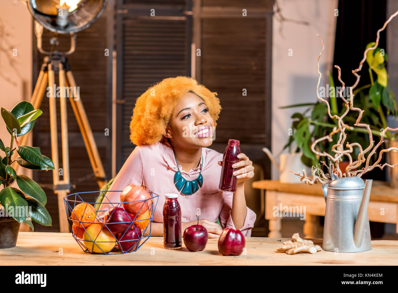 Donna con frutta e frullati a casa interno Foto Stock