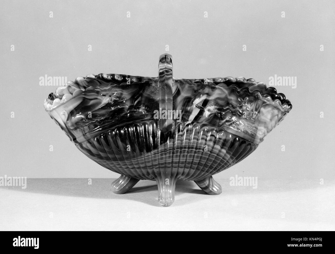 Un cesto di vetro di marmo viola pressato dal 1880 al 1890, di 2 3/8 x 4 5/8 pollici (6 x 11,7 cm), donato al Metropolitan Museum of Art dalla signora Emily Winthrop Miles nel 1946. Il cestino è un esempio della lavorazione artigianale del vetro del tardo XIX secolo. Foto Stock