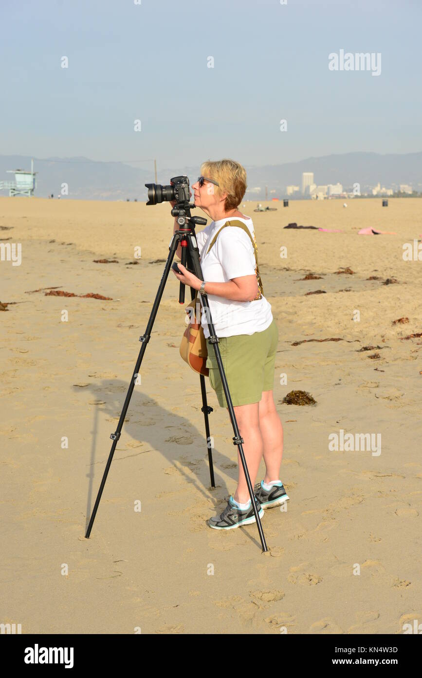 Una signora fotografo di scattare una foto a Venice Beach a Los Angeles Foto Stock