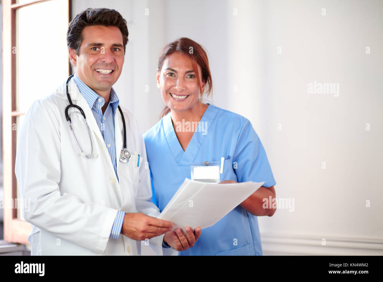 Ritratto di colleghi medici cercando e sorridente a voi mentre si tiene i documenti - copyspace. Foto Stock