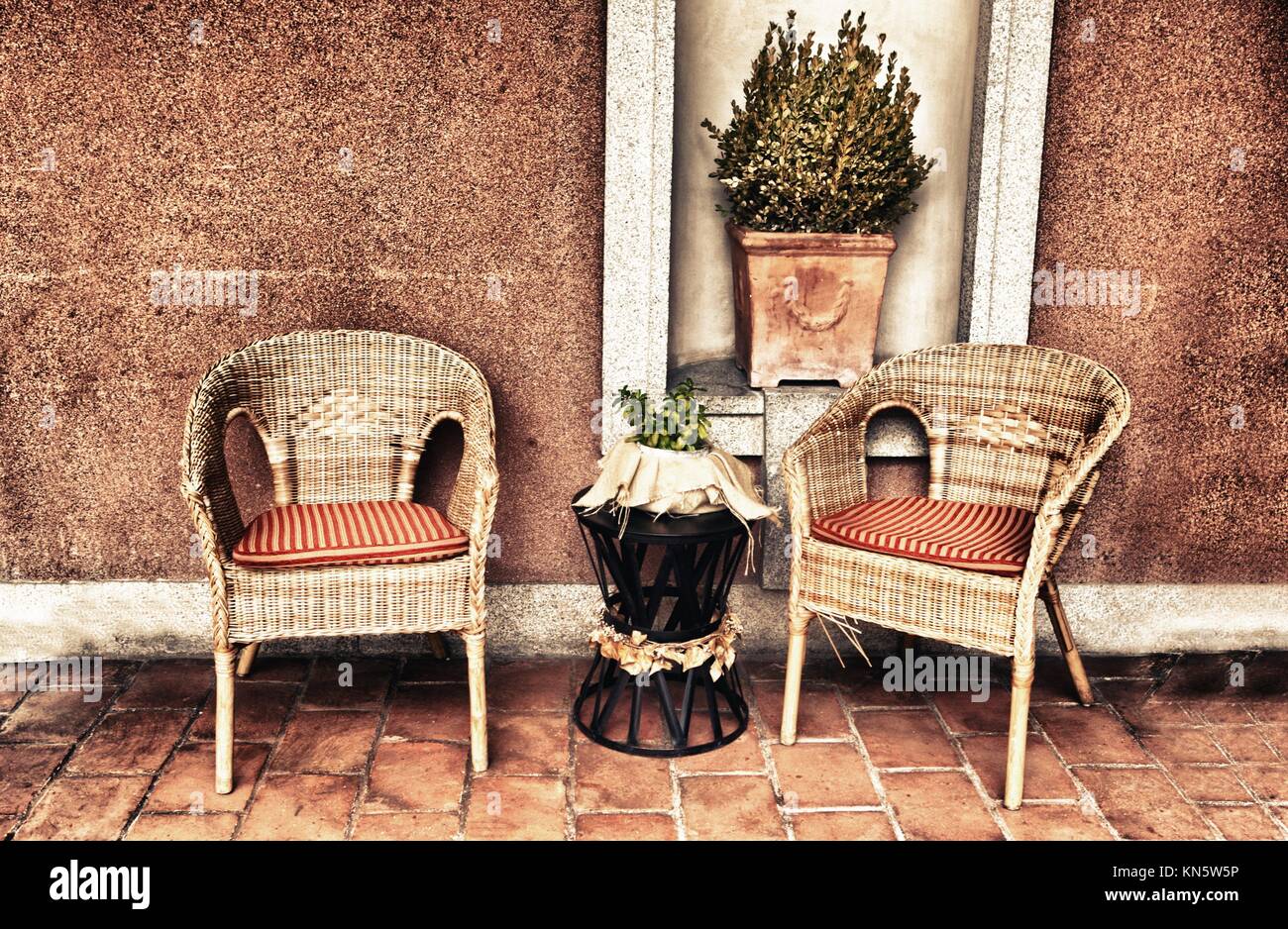 Vimini mobili veranda con vasi e piante in autunno. Foto Stock