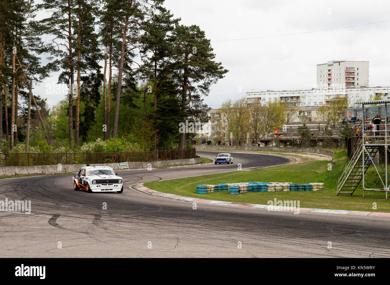 Due retrò era sovietica racing cars in curva ad s su una pista Bikernieku in Riga. Con una foresta su un lato e multi-storey flat case di distanza. Foto Stock