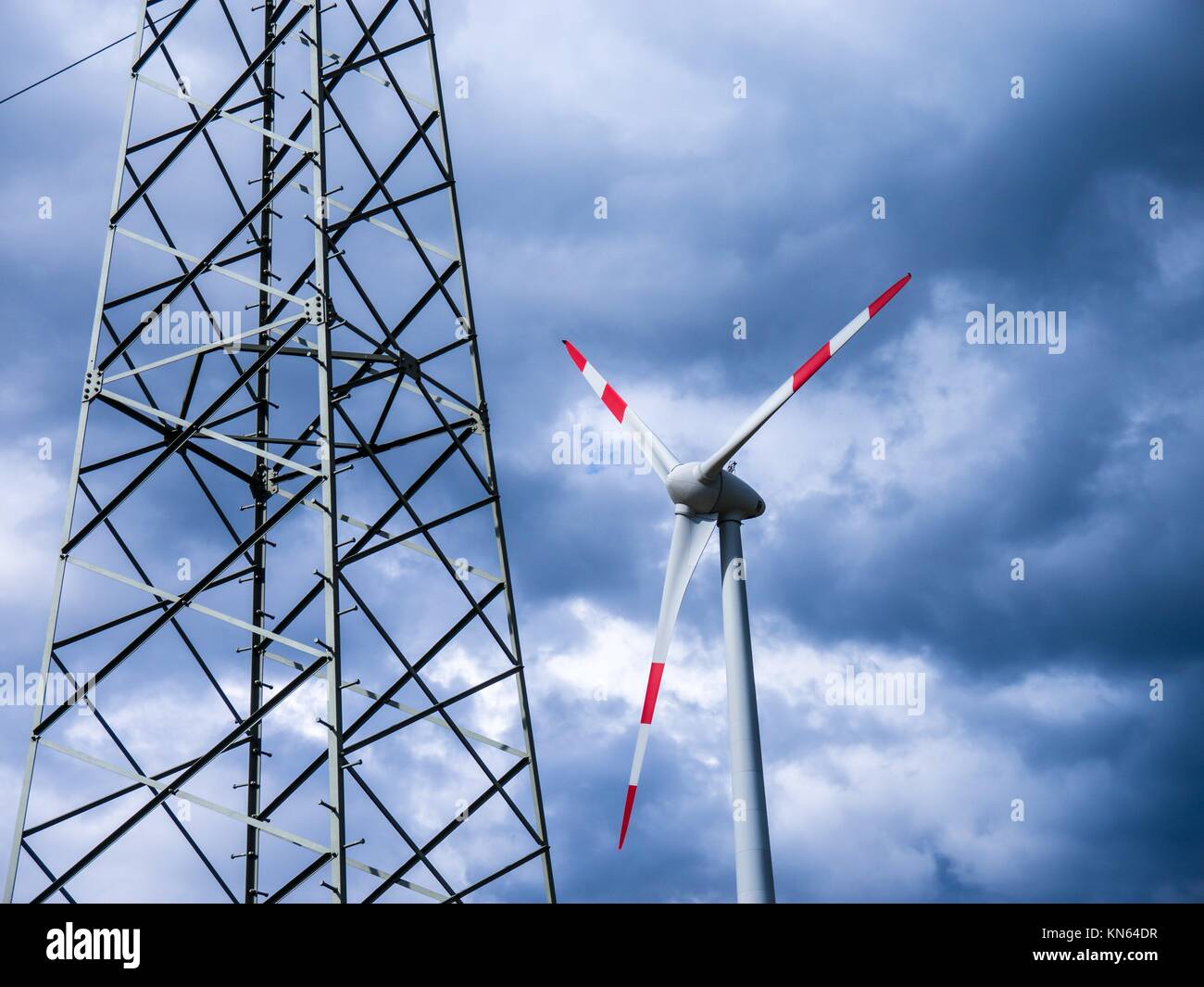 Torre elettrica e il generatore a vento e nuvole di tempesta (l'energia alternativa). Foto Stock