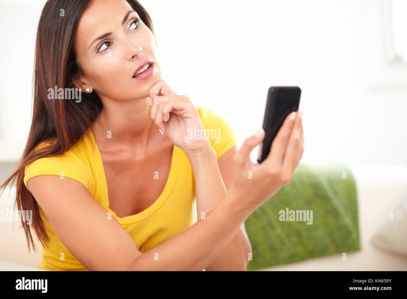 Vita ritratto di una giovane donna chiedendo tenendo un telefono cellulare. Foto Stock