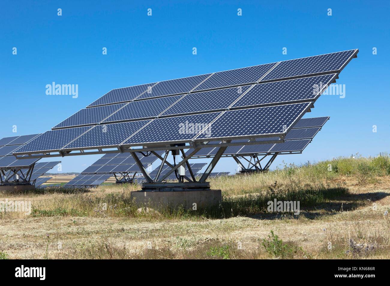 Solare fotovoltaico campo di pannelli per la produzione di energia da fonti rinnovabili con cielo blu, Spagna. Foto Stock