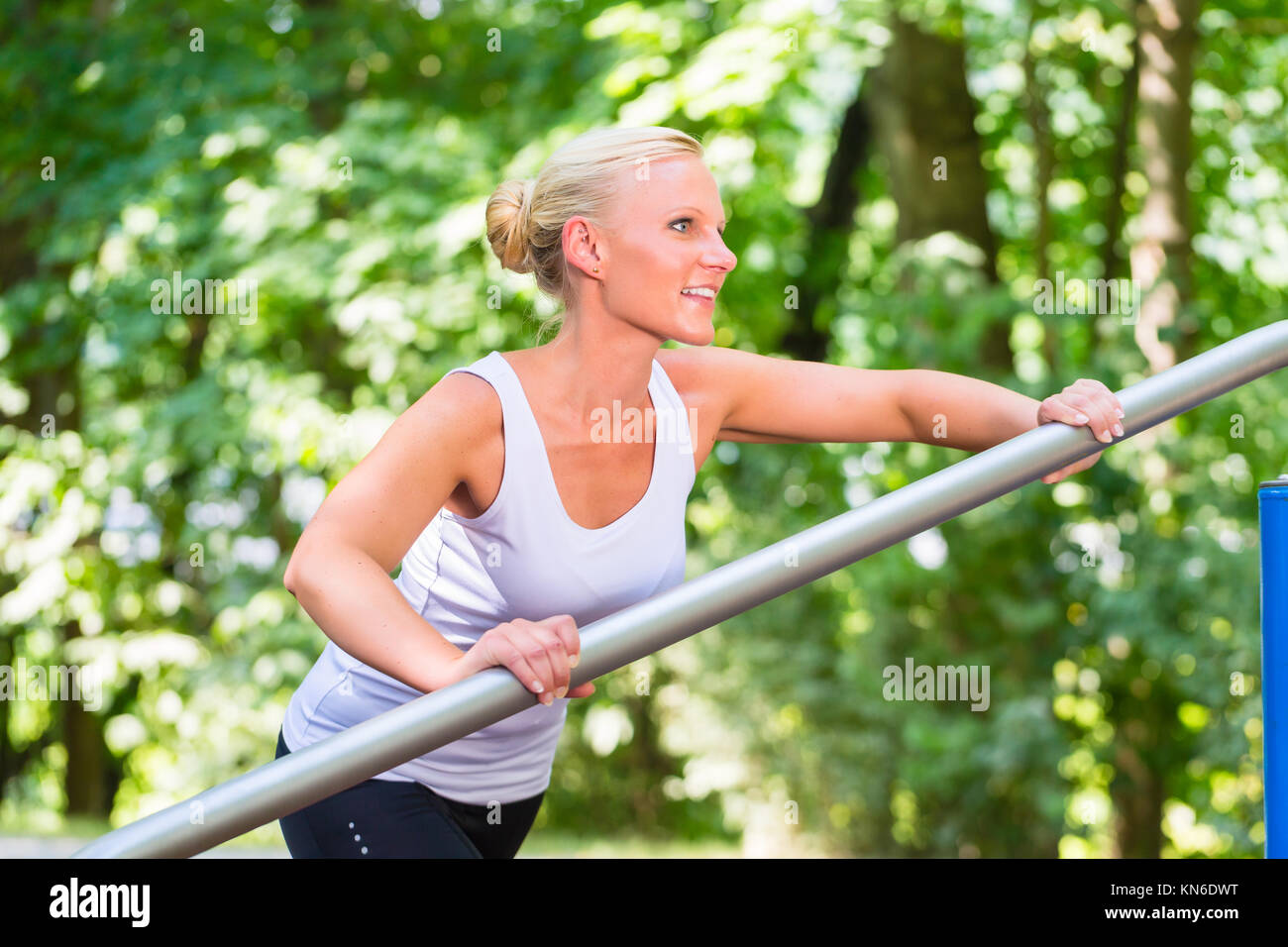 Giovane donna stretching prima di sport sul percorso fitness Foto Stock