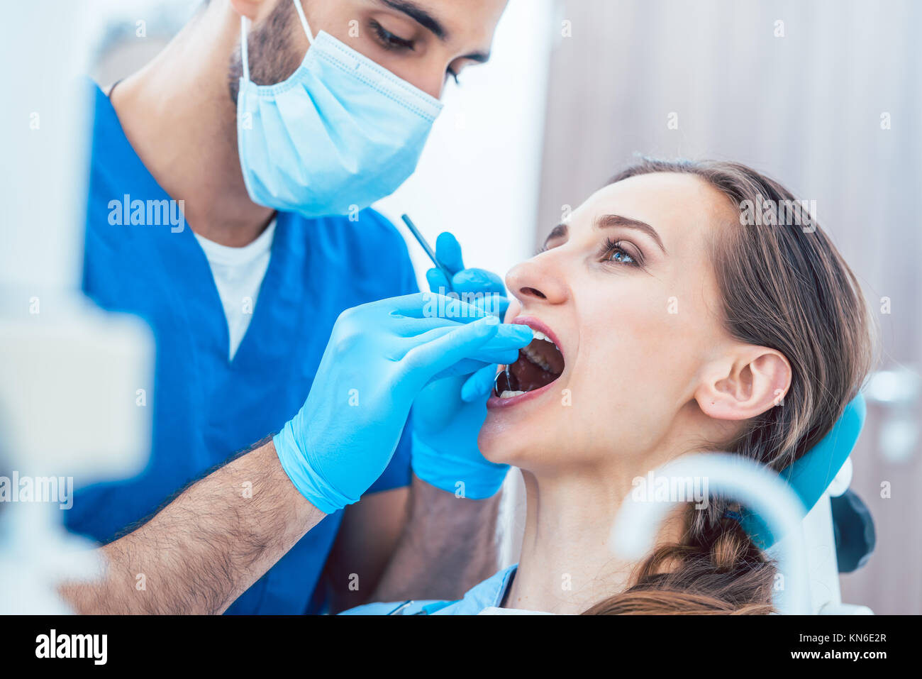 Giovane donna indolore durante la pulizia dei denti eseguita da un affidabile de Foto Stock