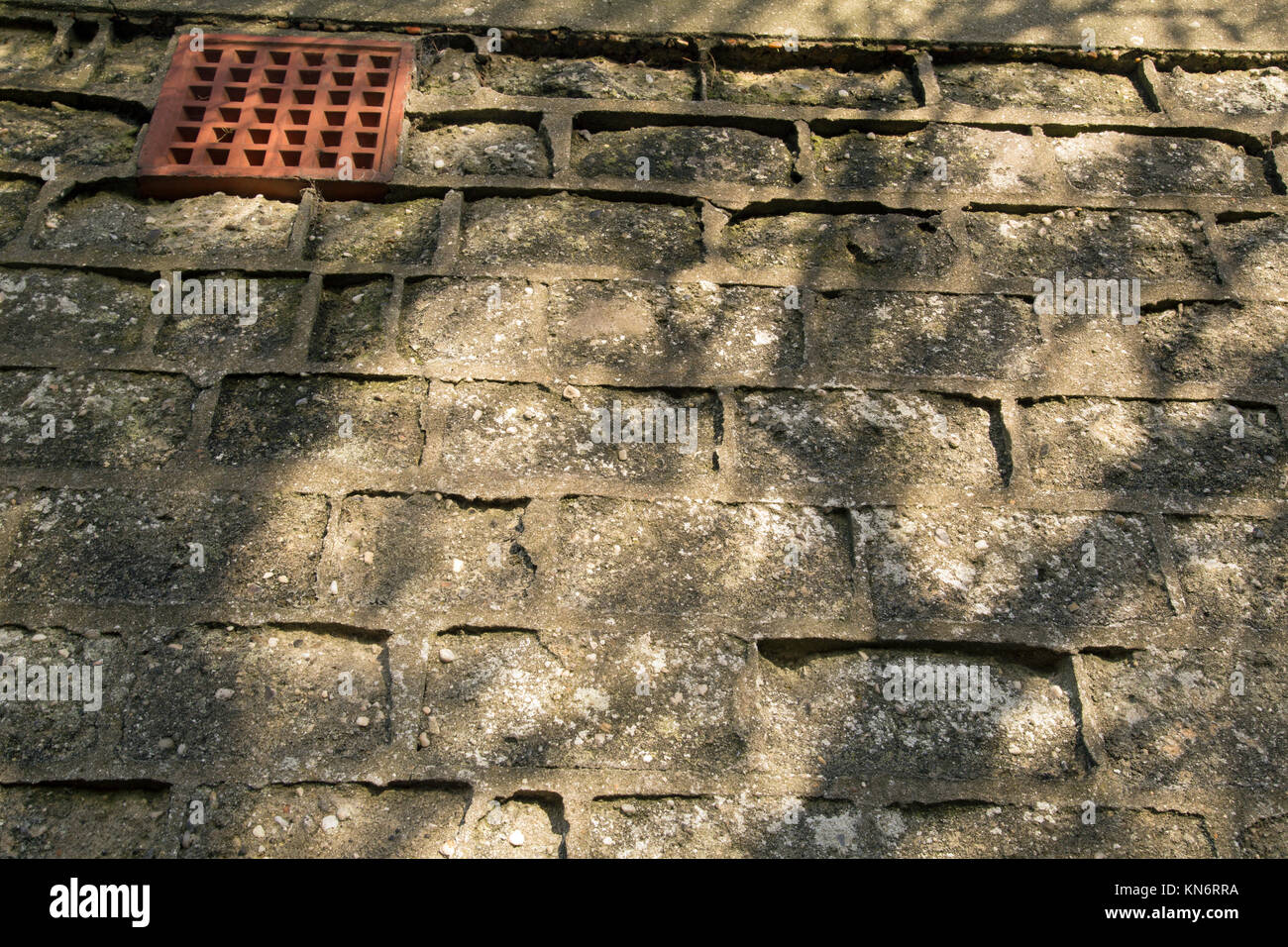 Close up orizzontale colpo di un calcestruzzo muro di mattoni con un aria di mattoni e ombre. Foto Stock