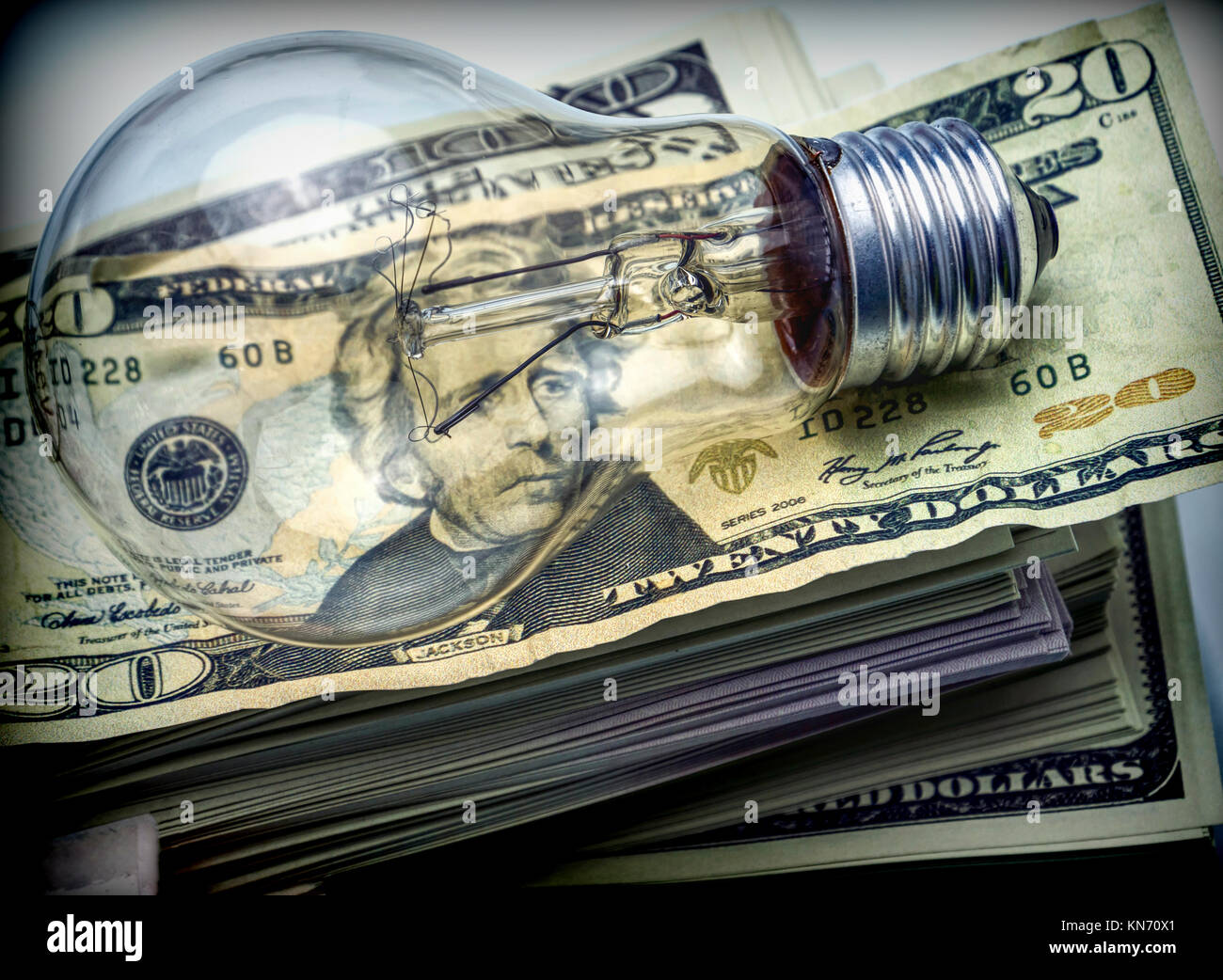 Una lampadina elettrica sul dollaro, il concetto di risparmio energetico Foto Stock