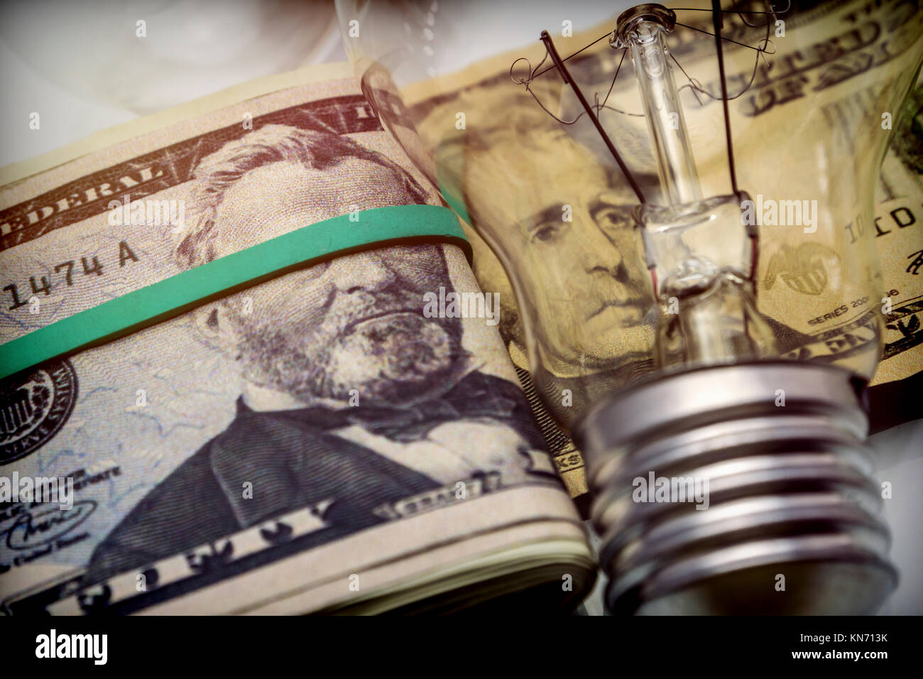 Una lampadina elettrica sul dollaro, il concetto di risparmio energetico Foto Stock