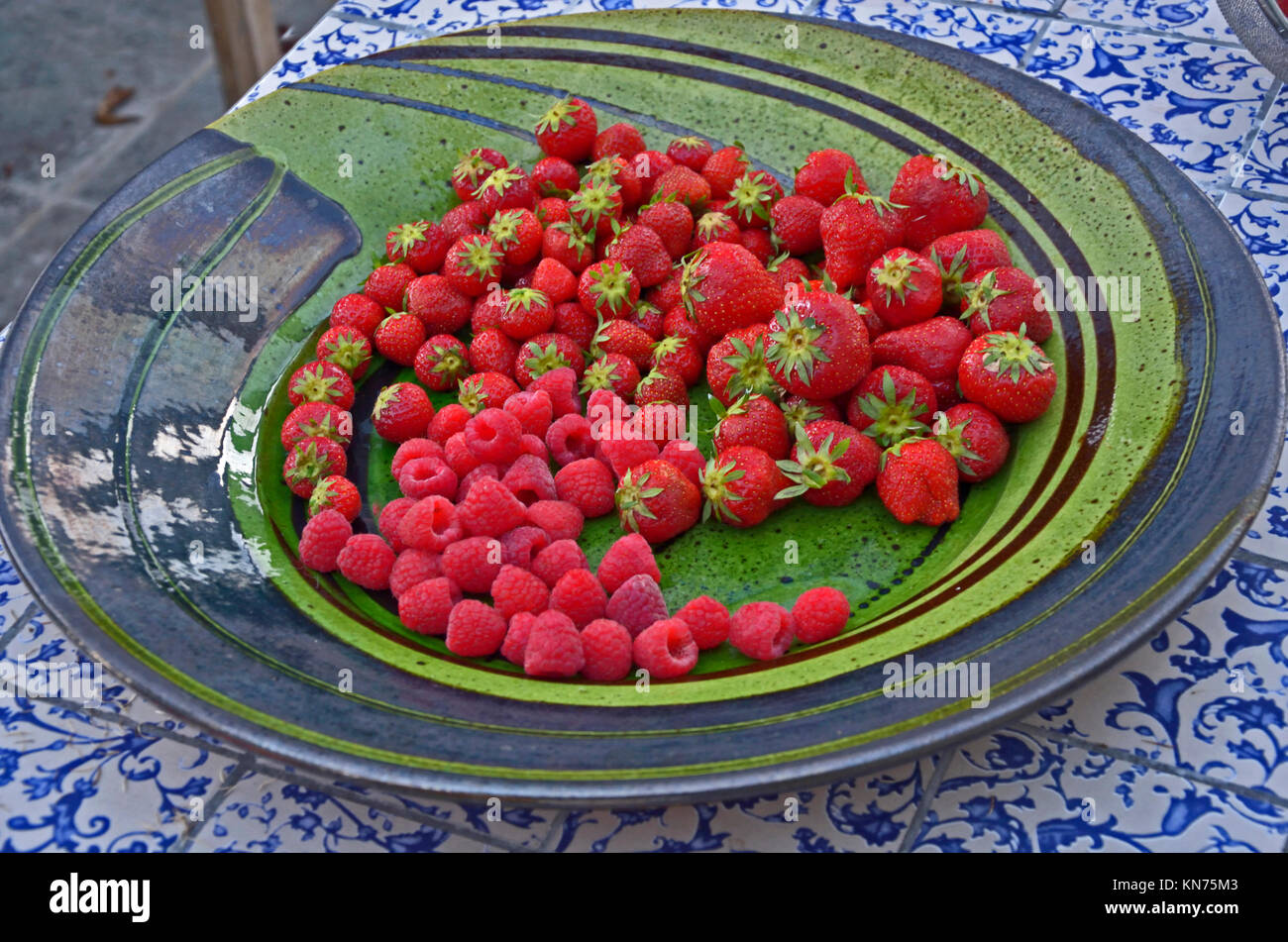 In prossimità di una ceramica decorativa piatto con fragole e lamponi Foto Stock