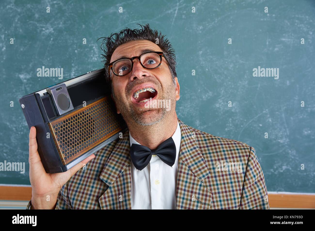 Nerd silly insegnante retrò uomo con bretelle e radio vintage e pazzo  espressione Foto stock - Alamy