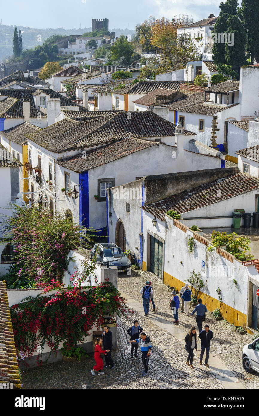 I turisti nelle strade acciottolate del borgo medievale di Obidos Portogallo Foto Stock