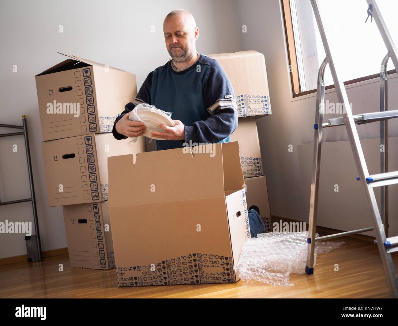 Persone casa in movimento, uomo piastre di imballaggio. Foto Stock
