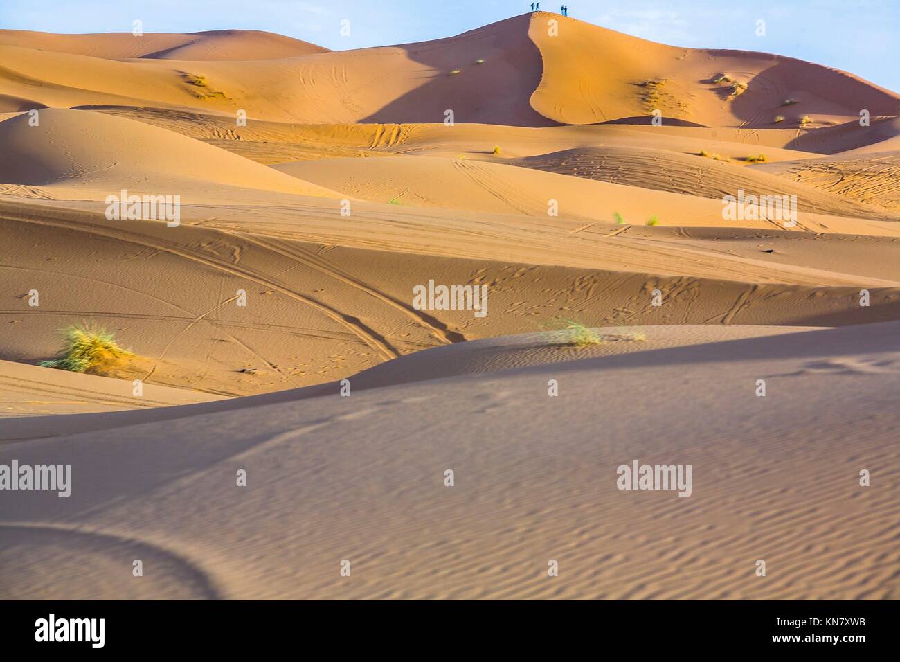 Persone ammirate il tramonto dalla collina. Diversi sand hill a Erg Chebbi nel deserto del Sahara. Ers sono grandi dune formate dal vento soffiato sabbia. Foto Stock