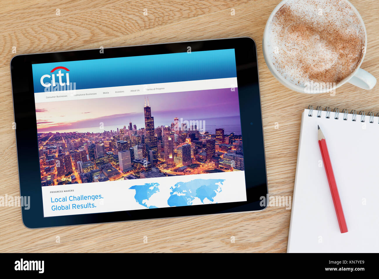 Il sito web di Citi su un iPad dispositivo tablet pc che si appoggia su una tavola di legno accanto a un blocco note e matita e una tazza di caffè (editoriale solo) Foto Stock