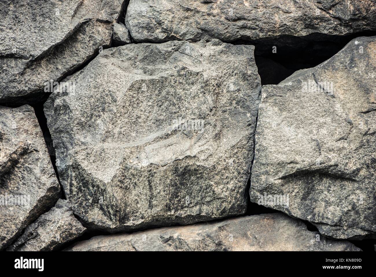 Sfondo di pietra, parete di roccia sullo sfondo con tessitura grossolana. Abstract, grungy e superficie testurizzata del materiale lapideo. La natura particolare delle rocce. Foto Stock