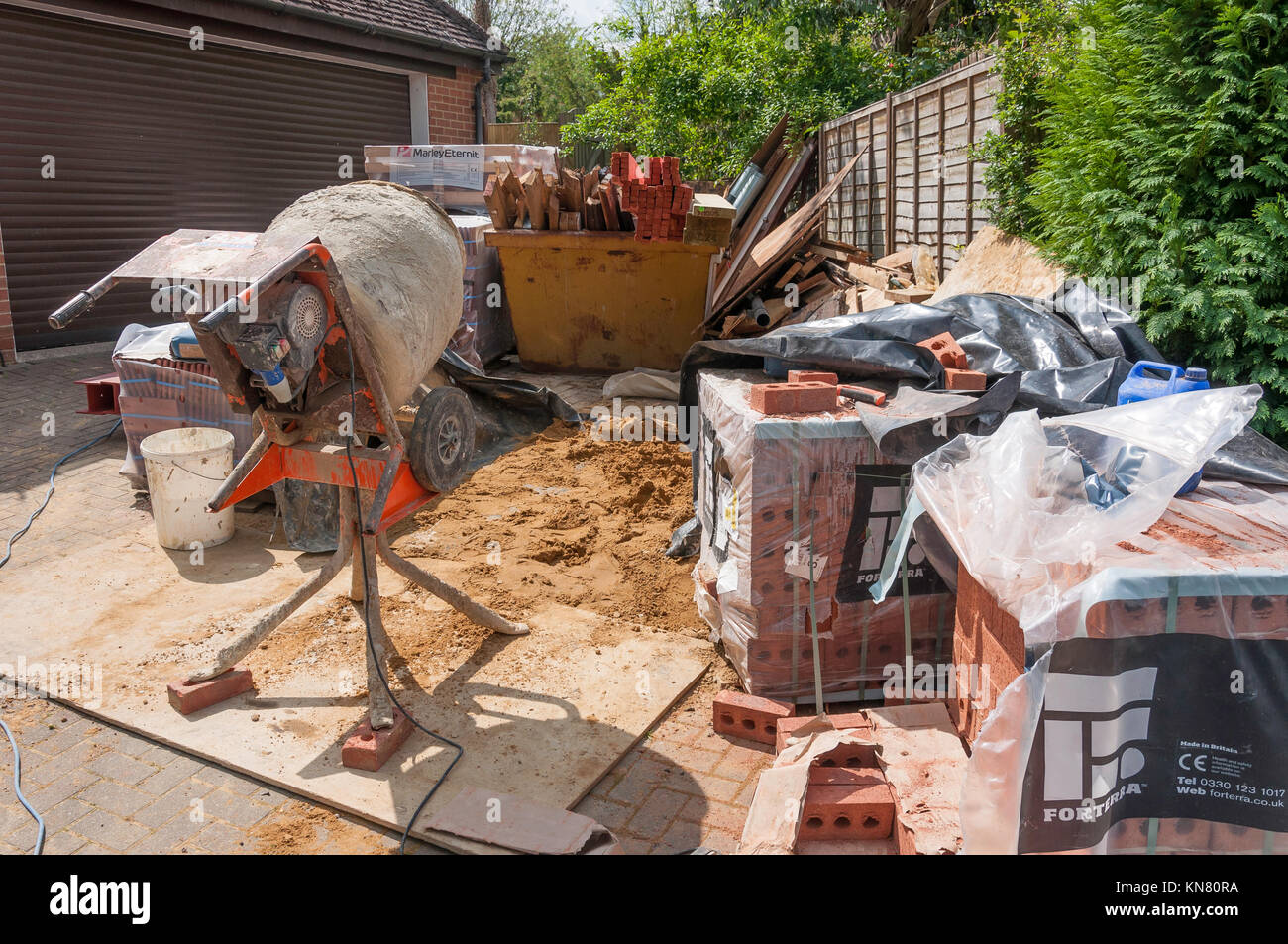 Builder stazione di lavoro con mescolatore di cemento, sabbia, mattoni e legno, Hungerford, Berkshire, Inghilterra, Regno Unito Foto Stock